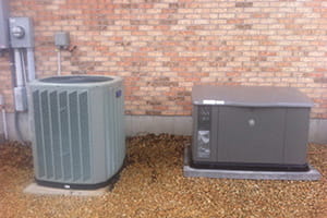 A standby generator sits next to an HVAC unit outside a home.