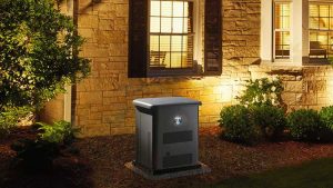 Standby generator in front of a well lit house.