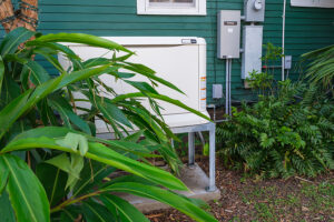 Home standby generator partially hidden behind greenery